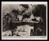Newspaper photo credited to Associated Press titled: Crewmen of the U.S.S. Saratoga. Shows them putting out fires on deck admidst the wreckage after being bombed by Japanese at Iwo Jima in Feb (1945) 